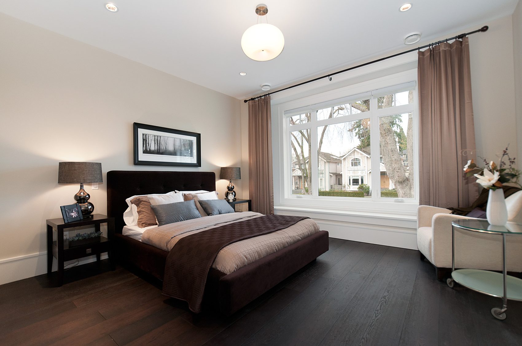Primary bedroom with dark wood flooring