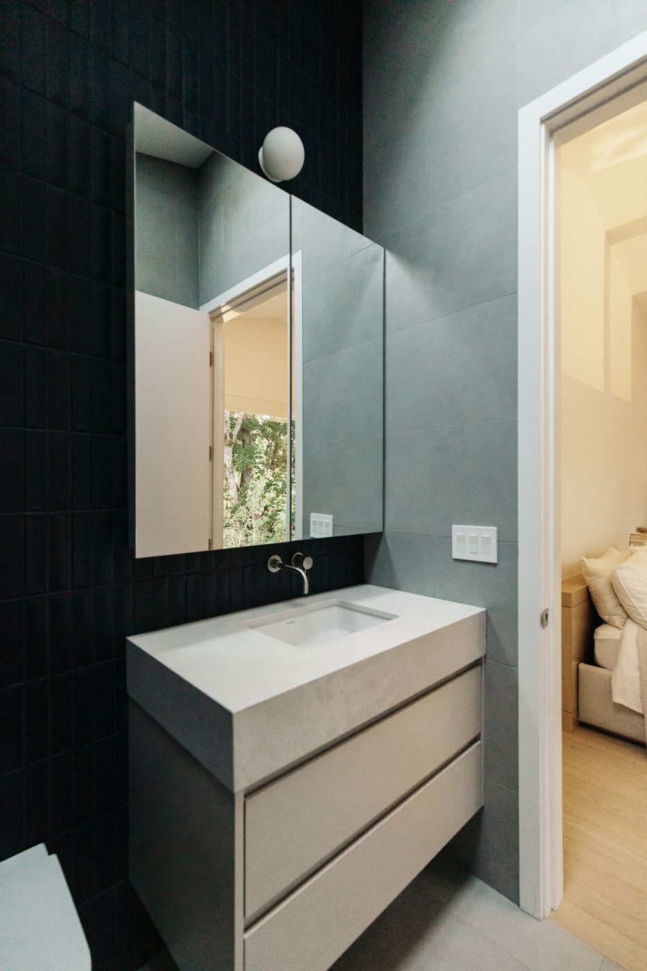 Powder room with dark tile and wood vanity