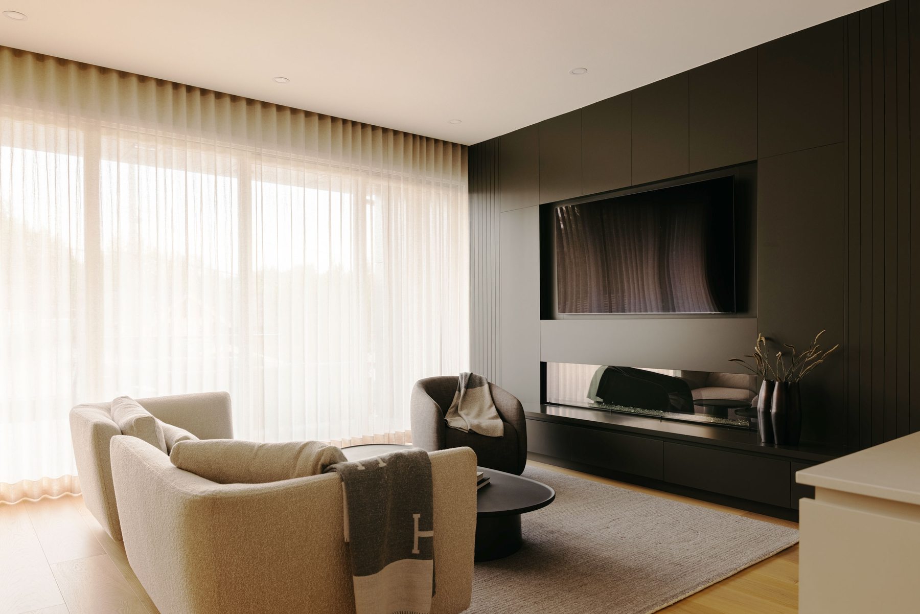 Living room with sheer curtains and built-in media wall
