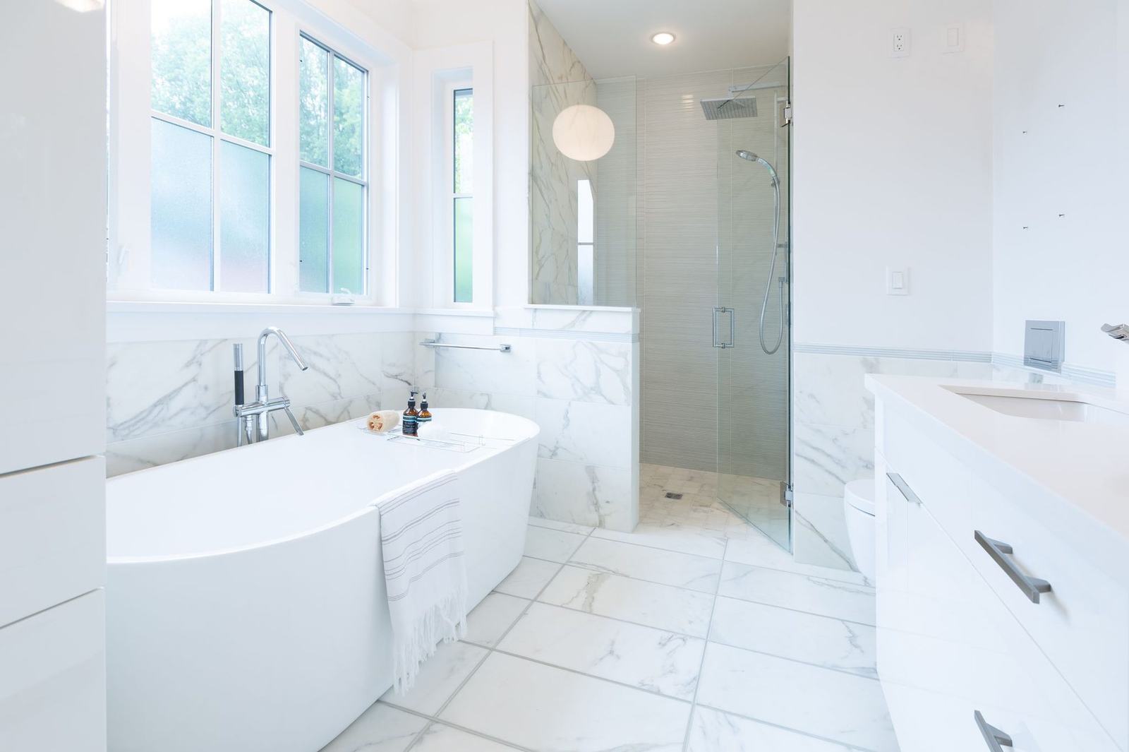 Primary bathroom with marble tile and freestanding tub