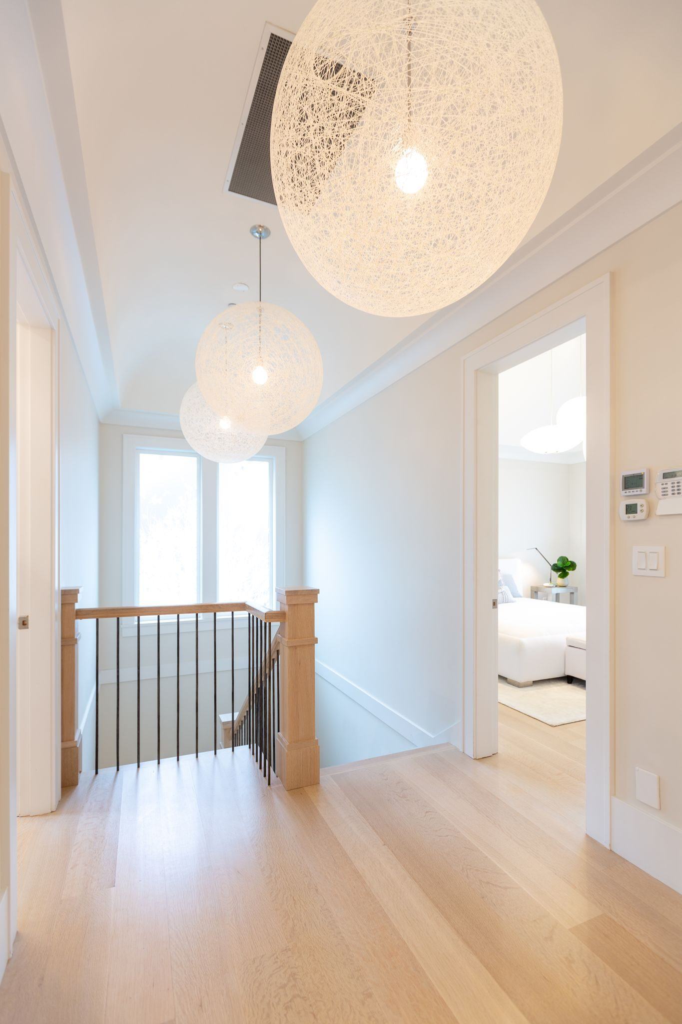 Upper hallway and staircase with sculptural pendant lighting